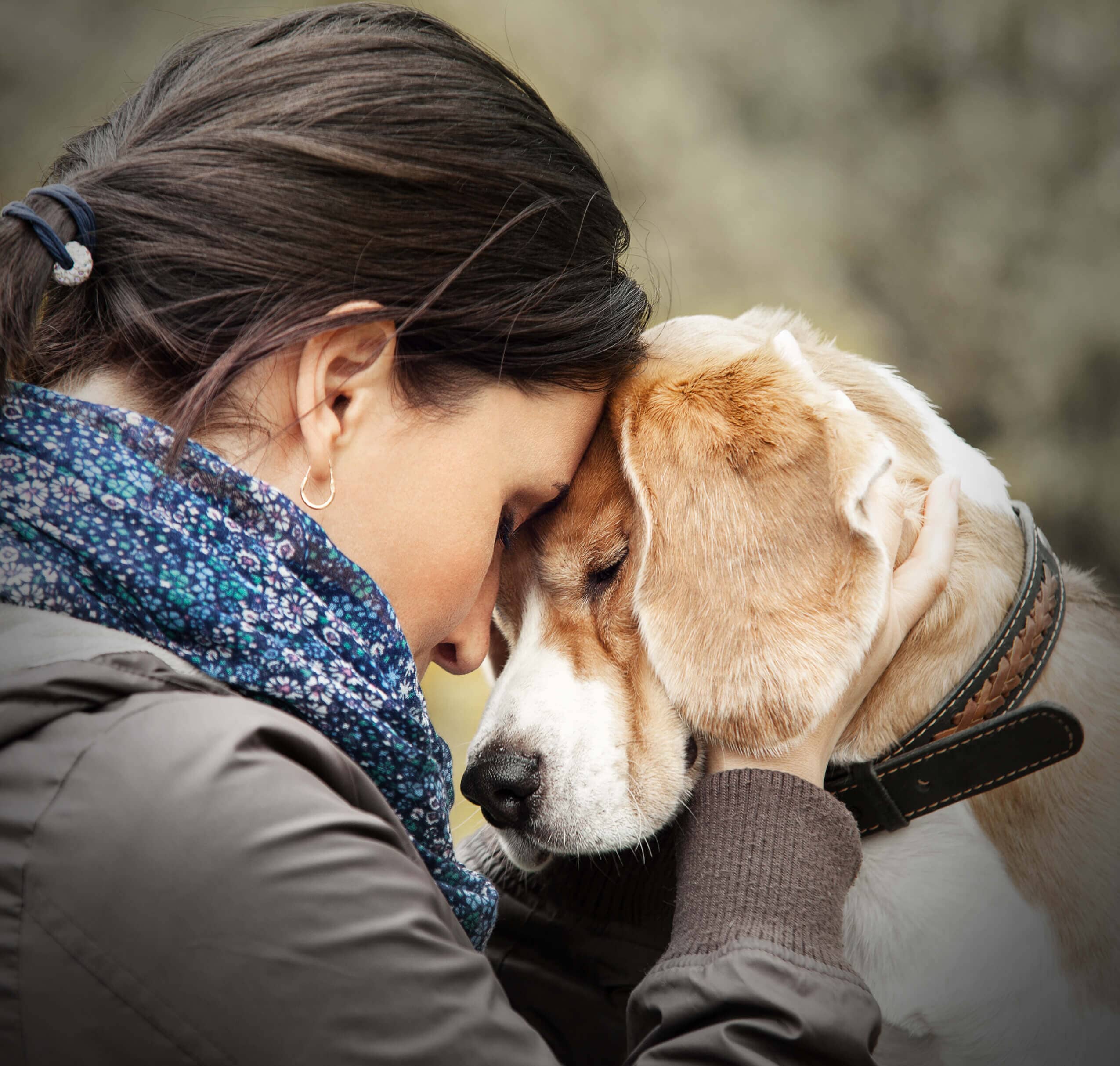 Dark haired woman cuddling dog